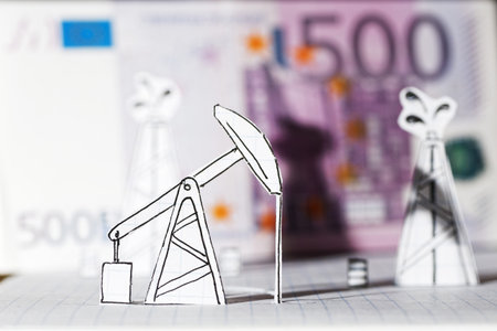 Petroleum pumpjack and oil rigs. Concept from paper against 500 euros on a blurry background....