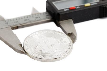 Closeup coin bitcoin measured with a caliper.
Concept of international virtual cryptocurrency, finances and management. Isolated on white. Shallow focus.の写真素材