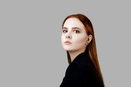 Portrait of a young long hair girl looking at the camera. Isolated on gray backgroundの写真素材