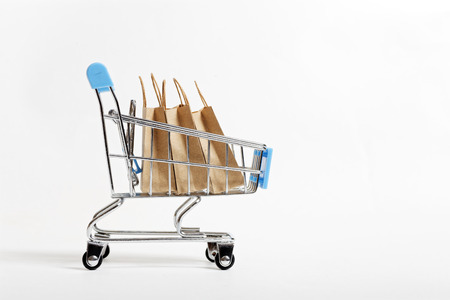 Supermarket trolley with paper shopping bags. Concept for Black Friday on white background with copyspace.の写真素材