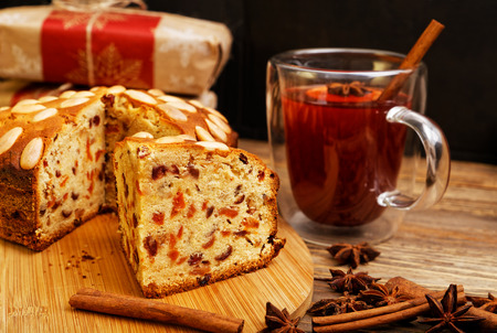 Homemade cake with almonds and a mug of mulled wine on wooden table. Shallow focus.の写真素材