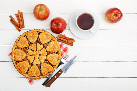 Homemade apple pie with cinnamon and cup of tea on white wooden table. Top view. Copyspace.の写真素材