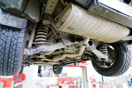 Old car on the lift in the service center against blurred background. View of the rear suspension of the car.の写真素材