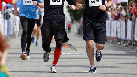 Marathon running race. Athletes runners run on a sports track.の写真素材