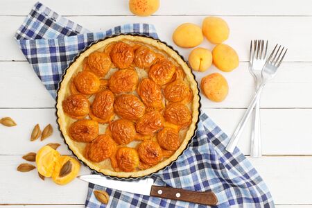 Homemade apricot pie with fresh fruits on white wooden table. Top view.の写真素材