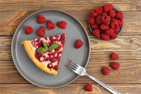 Closeup piece of homemade raspberry pie with yogurt filling on wooden table. Top view.の写真素材