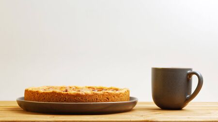 Homemade apple pie and cup of tea on wooden table. Front view with copy space.の写真素材