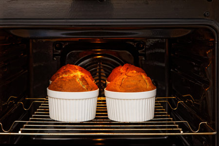 Homemade cakes in white ceramic mold is baked in the oven. Shallow focus.の写真素材