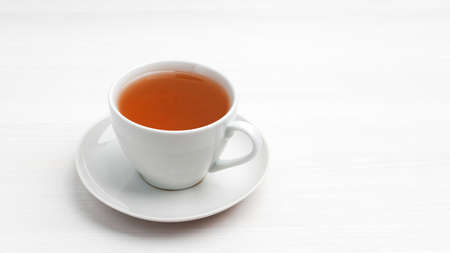 White cup of tea on a white wooden table. Copyspace.の写真素材