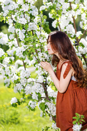 Portrait of a woman with flowering apple tree. Shallow focus.の写真素材