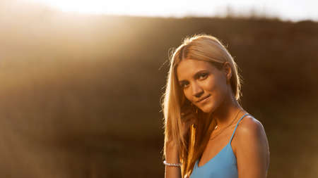 Portrait of a young attractive girl in backlight against blurred background. Shallow focus. Copyspace.の写真素材