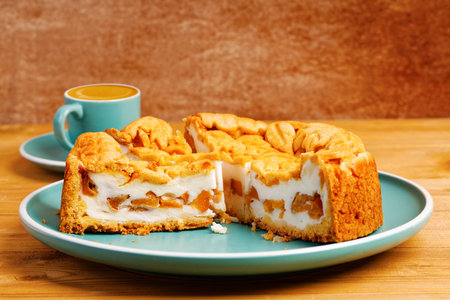 Homemade pie with nectarines and cup of coffee espresso on wooden table. Shallow focus.の写真素材