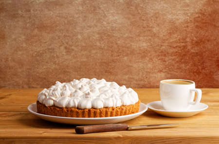 Homemade berry pie decorated with meringue and a cup of coffee on a wooden table. copyspace.の写真素材