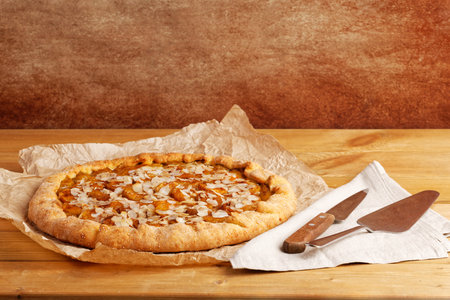 Homemade pie with plums and almond petals on parchment paper. copyspace.の写真素材
