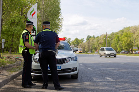 Ulyanovsk, Russia - May 20, 2023: Russian traffic police officers in uniform and his police car on the city streetのeditorial素材