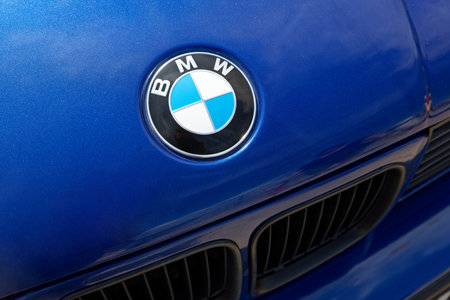 Ulyanovsk, Russia - July 29, 2023: Fragment of the hood and front of the blue car BMW with the emblem.のeditorial素材