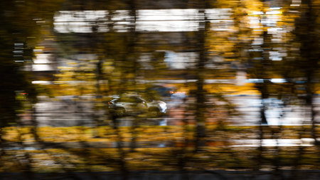Cars ride along the autumn street at night. Motion blur.