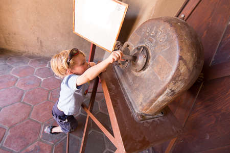 Boy playing with old farm machinery at Scotty's Castle, Death Valley.のeditorial素材