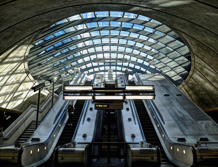 LONDON, UK - February 8, 2014: Interior shot of Canary Wharf Underground Station. The usually busy underground station shown on a quiet Saturday morning with two unidentified travellers on the escalators. Designed by the architect Sir Norman Foster.のeditorial素材