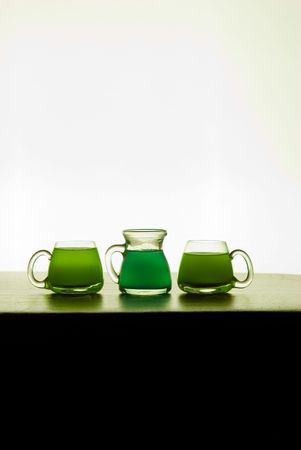 different glasses and glass bottles filled with colored liquidの写真素材