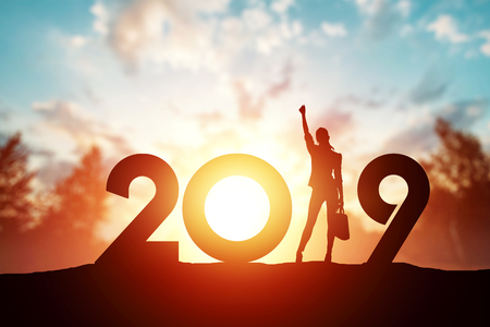 Creative background, Silhouette young woman Enjoying on the hill and 2019 years while celebrating new year. Happy New Year 2019, copy space.の写真素材
