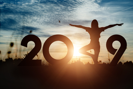 Creative background, Silhouette young woman practicing yoga on 2019 new year. Happy New Year 2019, copy space.の写真素材