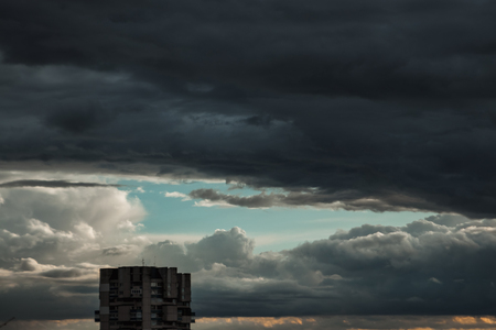 Dark, dramatic clouds, time before a storm, thundery fluffy clouds. Thunderstorm in the city.の写真素材