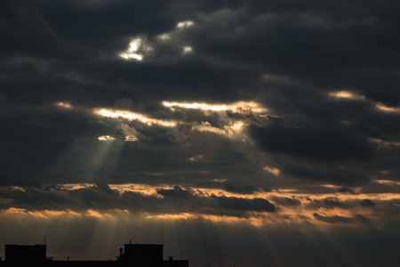 Sun shining through thick cloudy sky, silver liningの写真素材