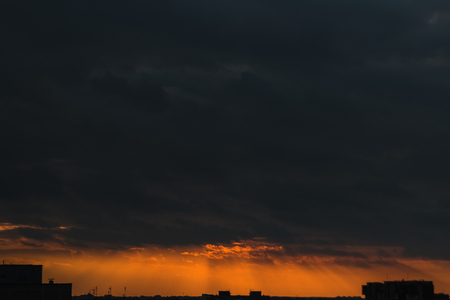 Creative background, orange sunset, rain clouds, clouds. Evening light, before a thunderstorm.の写真素材