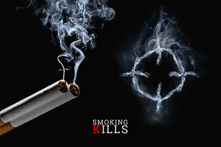 Cigarettes close-up on a black background, cigarette smoke, a target. Creative background. The concept of smoking kills, nicatine poisons, cancer from smoking, stop smoking. Copy space.の写真素材