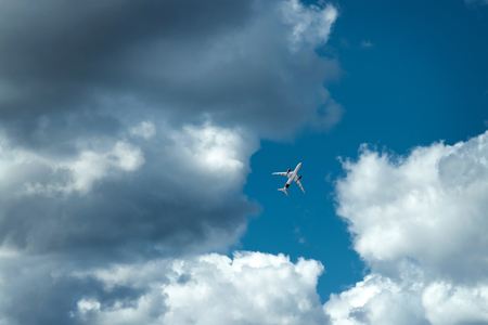 The plane against the blue sky and fluffy clouds. Concept of vacation, vacation, flight, travel.の写真素材