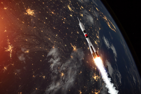 The rocket flies in space against the backdrop of the earth. The concept of space exploration, satellite launch, flight to the moon, free internet.の写真素材