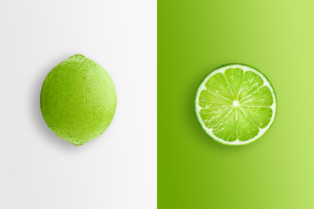 Creative background, lime and lime slices on a white and green background. Flat lay, copy space, layout. The concept of nutrition, fresh fruit, natural products, juice.の写真素材