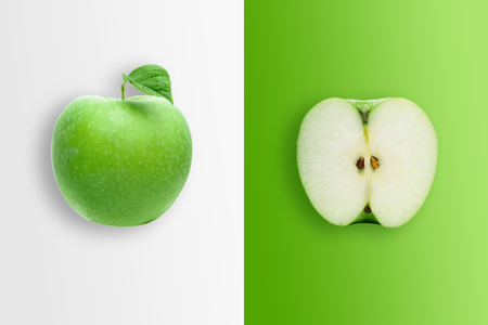 Creative background, green apple and slices of apple on a white and green background. Flat lay, copy space, layout. The concept of nutrition, fresh fruit, natural products, juice.の写真素材
