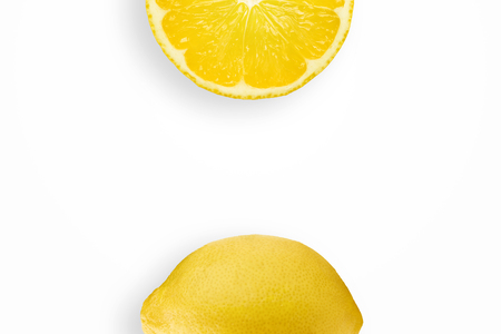 Creative background, lemon and lemon slices on a white background. Flat lay, copy space, layout. The concept of nutrition, fresh fruit, natural products, juice.の写真素材