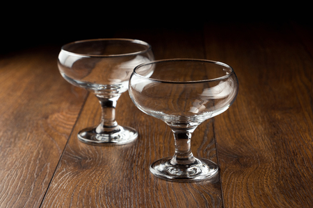 empty glass cups on a brown wooden background, tableware.の写真素材