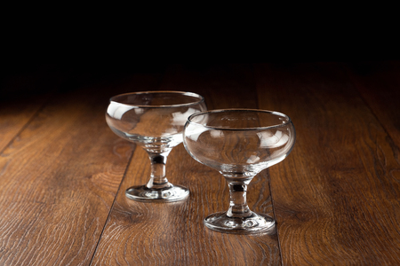 empty glass cups on a brown wooden background, tableware.の写真素材