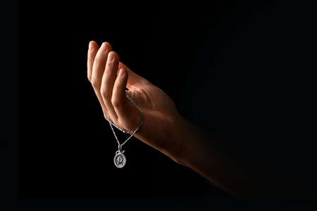 Men's hands in prayer on a black background. The concept of faith, prayer, mourning, forgiveness, confession.の写真素材