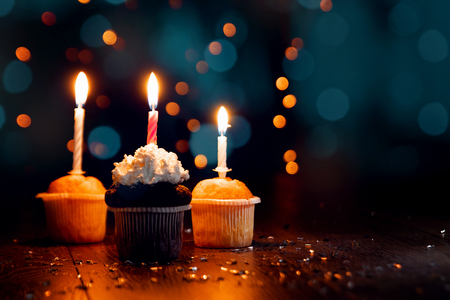 Creative background, cupcake with candles, beautiful bokeh. Happy Birthday. Present. Concept for Holiday Card, Flyer, Background. Copy spaceの写真素材