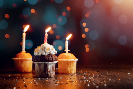 Creative background, cupcake with candles, beautiful bokeh. Happy Birthday. Present. Concept for Holiday Card, Flyer, Background. Copy spaceの写真素材