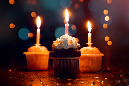 Creative background, cupcake with candles, beautiful bokeh. Happy Birthday. Present. Concept for Holiday Card, Flyer, Background. Copy spaceの写真素材