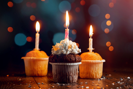 Creative background, cupcake with candles, beautiful bokeh. Happy Birthday. Present. Concept for Holiday Card, Flyer, Background. Copy spaceの写真素材