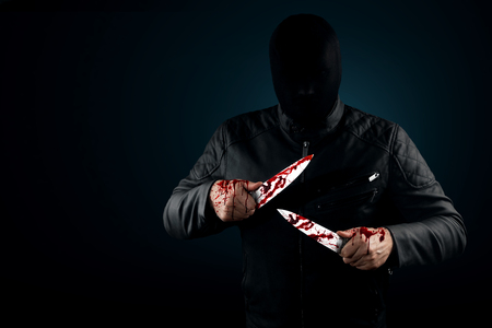 A serial killer, a maniac with a knife and splashes of blood. Halloween concept, psychopath. Copy space.の写真素材