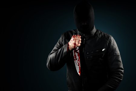 A serial killer, a maniac with a knife and splashes of blood. Halloween concept, psychopath. Copy space.の写真素材