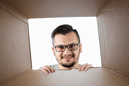 Unboxing, Creative background, a man opens the box and looks inside. The package, delivery,...