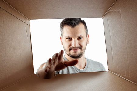 Unboxing, Creative background, a man opens the box and looks inside. The package, delivery,...