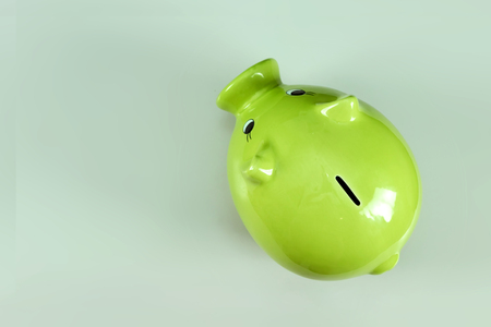 Creative background, green pig money box on gray background top view, flat lay. The concept of saving money, savings, pig piggy, family budget, copy space.の写真素材