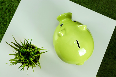 Creative background, green pig money box on gray background top view, flat lay. The concept of saving money, savings, pig piggy, family budget, copy space.の写真素材