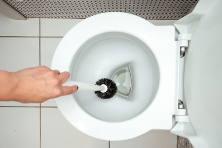 Close-up, Female hand washes a toilet brush. The concept of cleanliness in the house, hygiene, toilet, microbes.の写真素材