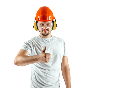 Male builder in orange helmet shows thumb up isolated on white background. Concept building, contractor.の写真素材